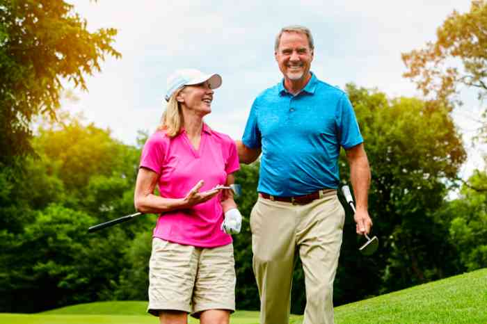 Male and Female couple on a golf green in summer laughing