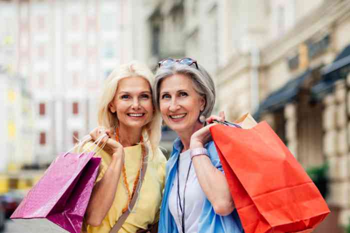 Mother and daughter outside in the city holding shopping bags