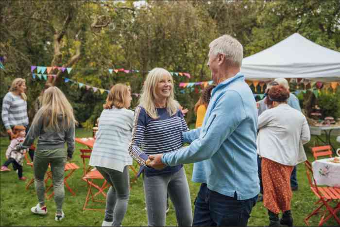 Man and woman laughing and dancing at an outdoor party