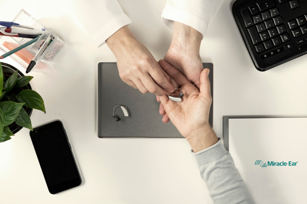 Miracle-Ear audiologist showing RIC hearing aid