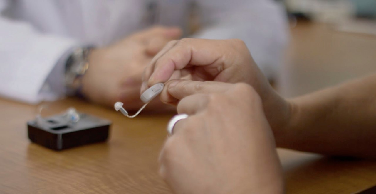 Miracle-Ear audiologist cleaning RIC hearing aid